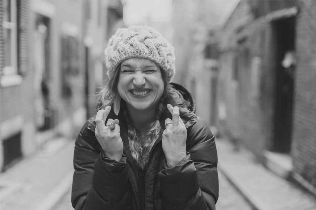 Lucky girl smiling and crossing her fingers